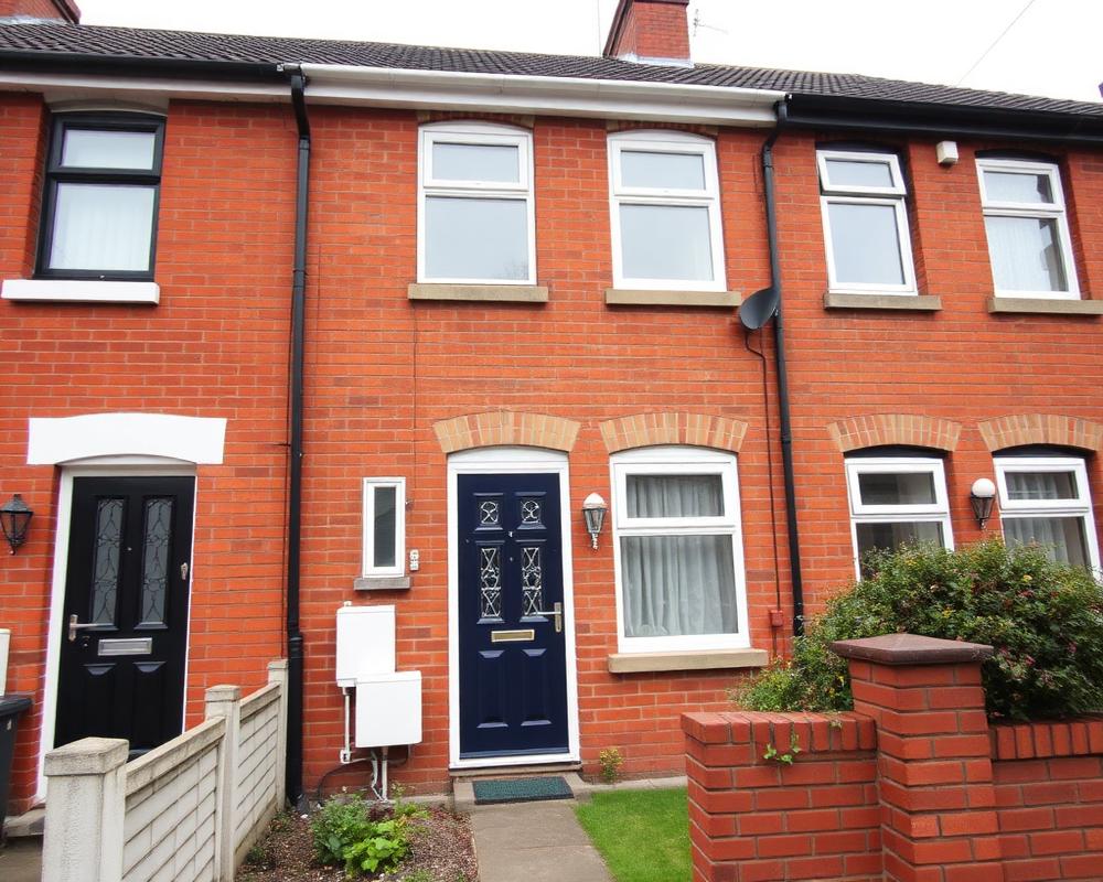 A well-maintained British terraced house with a navy front door